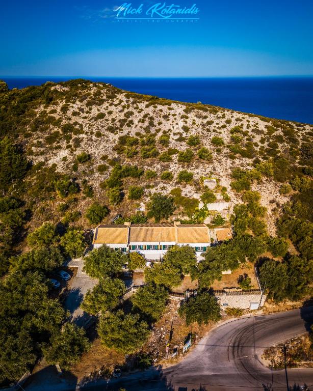a building on the side of a hill next to the ocean at Sofia and Soul Studios in Kalamitsi