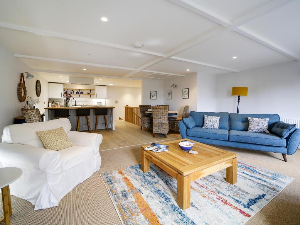 un salon avec deux canapés et une table dans l'établissement Joinery Cottage, à Porthleven