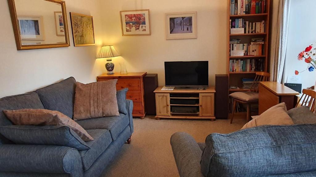 a living room with a couch and a tv at 5 Greta Side Court in Keswick