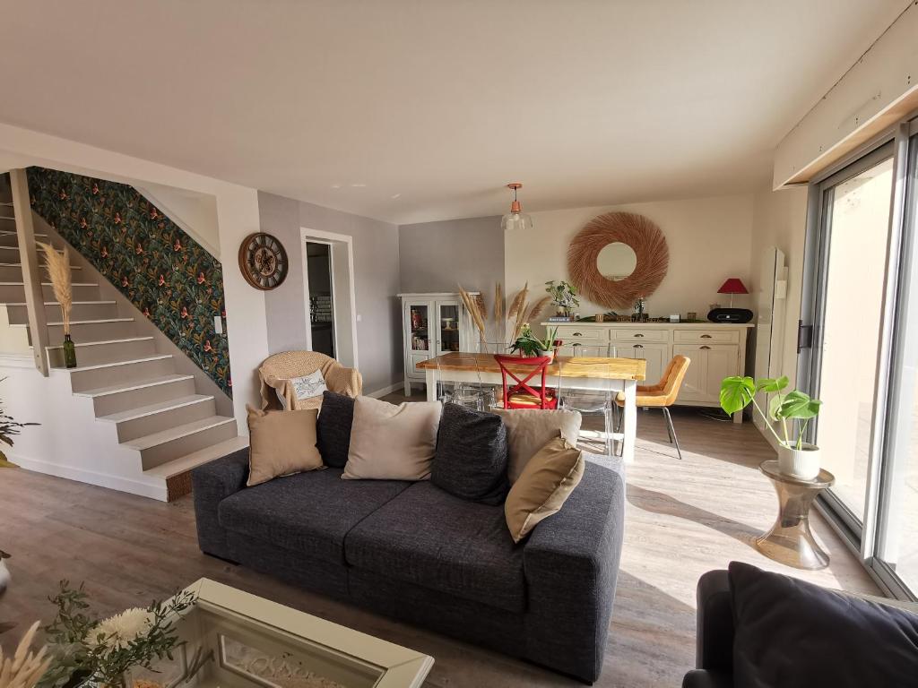 ein Wohnzimmer mit einem Sofa und einem Tisch in der Unterkunft Au numéro Cinq in Donville-les-Bains