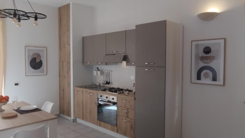 a kitchen with gray cabinets and a stove top oven at LechicchediLampedusa in Lampedusa
