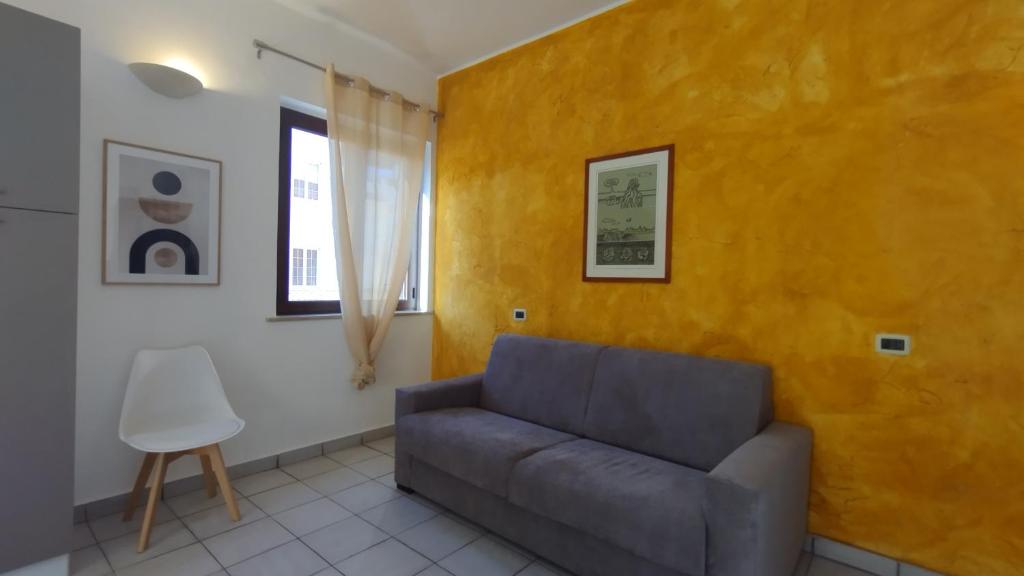 a living room with a couch and a yellow wall at LechicchediLampedusa in Lampedusa