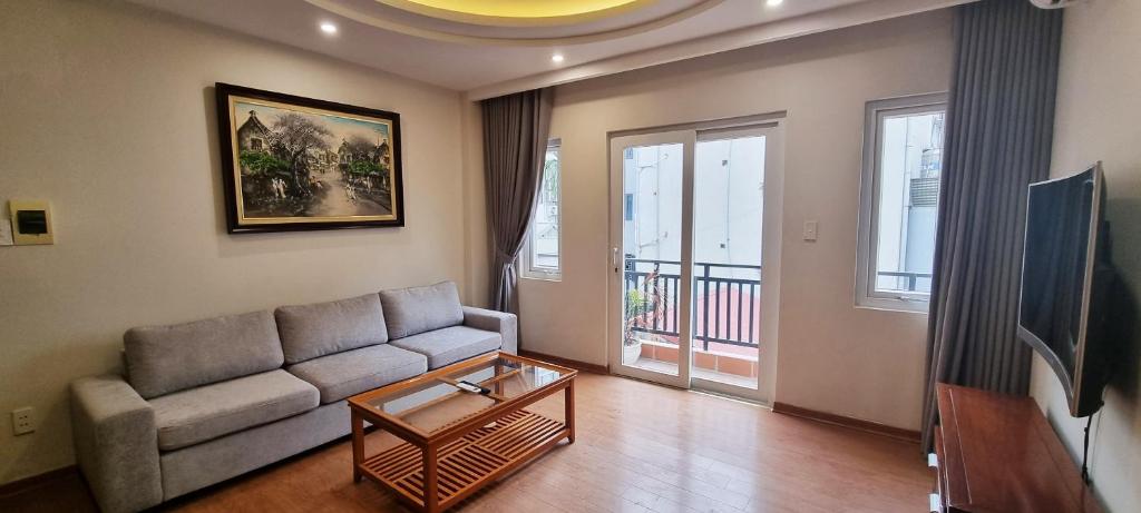 ein Wohnzimmer mit einem Sofa und einem Tisch in der Unterkunft Ruby Serviced Apartment Phan Ke Binh in Hanoi