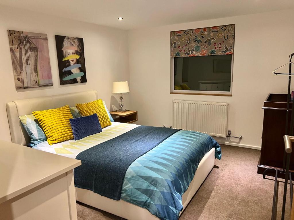 een slaapkamer met een bed en een flatscreen-tv bij Gorgeous Cosy home 2 Miles from Heathrow Airport in Ashford