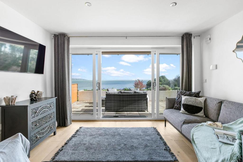 - un salon avec un canapé et une vue sur l'océan dans l'établissement Osprey 3, The Cove, Brixham, à Brixham