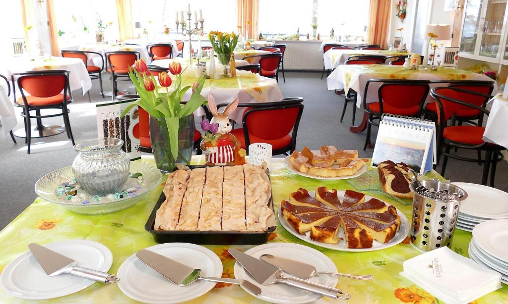 una mesa con comida y platos en un restaurante en Hotel Diekseequell Superior am Dieksee, en Malente