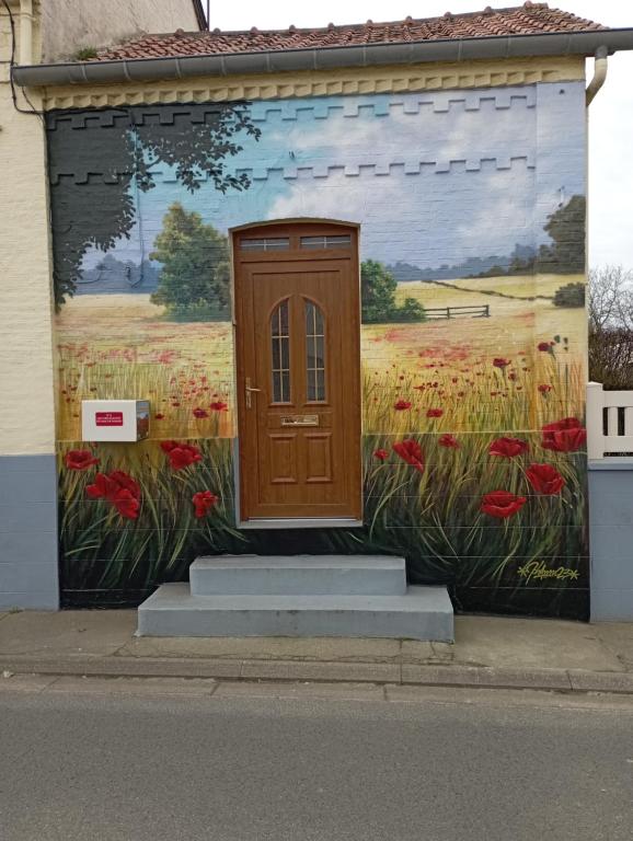 un dipinto di una porta sul lato di un edificio di Les coquelicots en Baie de Somme a Saint-Blimont