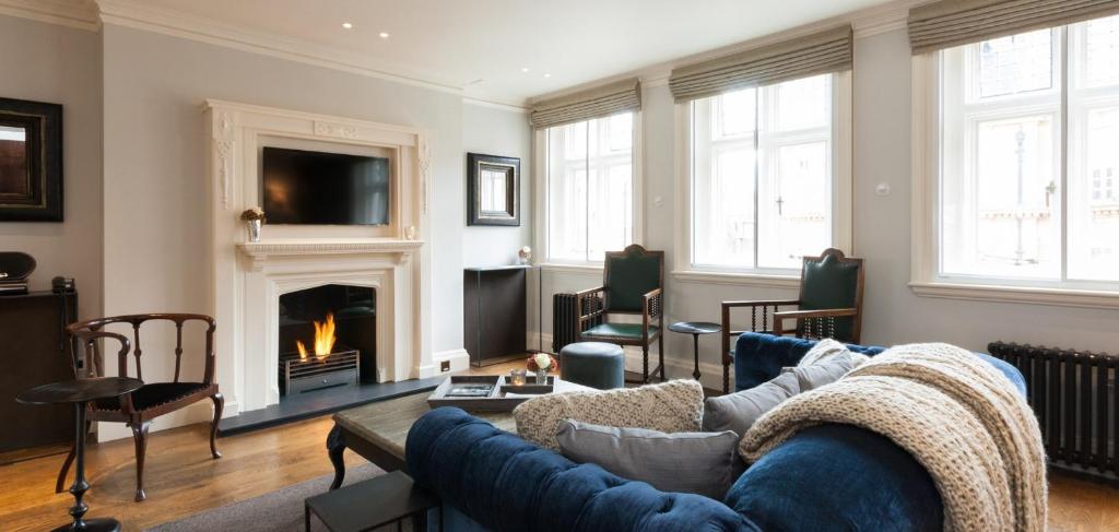un soggiorno con divano e camino di The Grosvenor Square Penthouse a Londra
