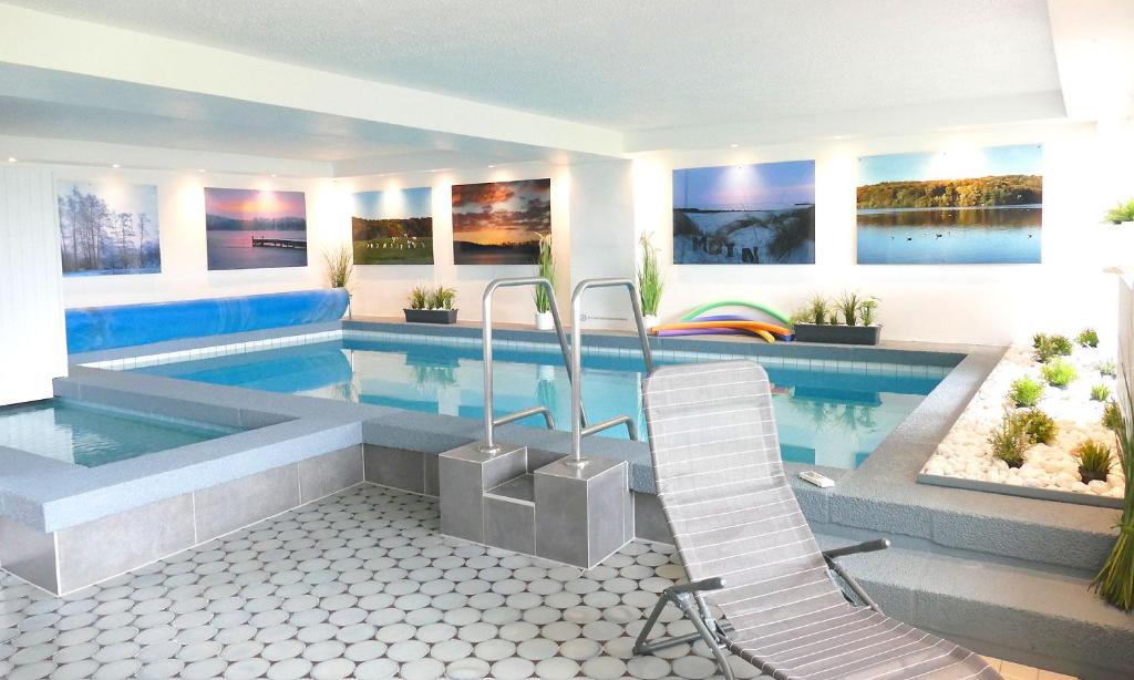 einen Pool mit einem Stuhl in einem Haus in der Unterkunft Hotel Diekseequell Superior am Dieksee in Malente
