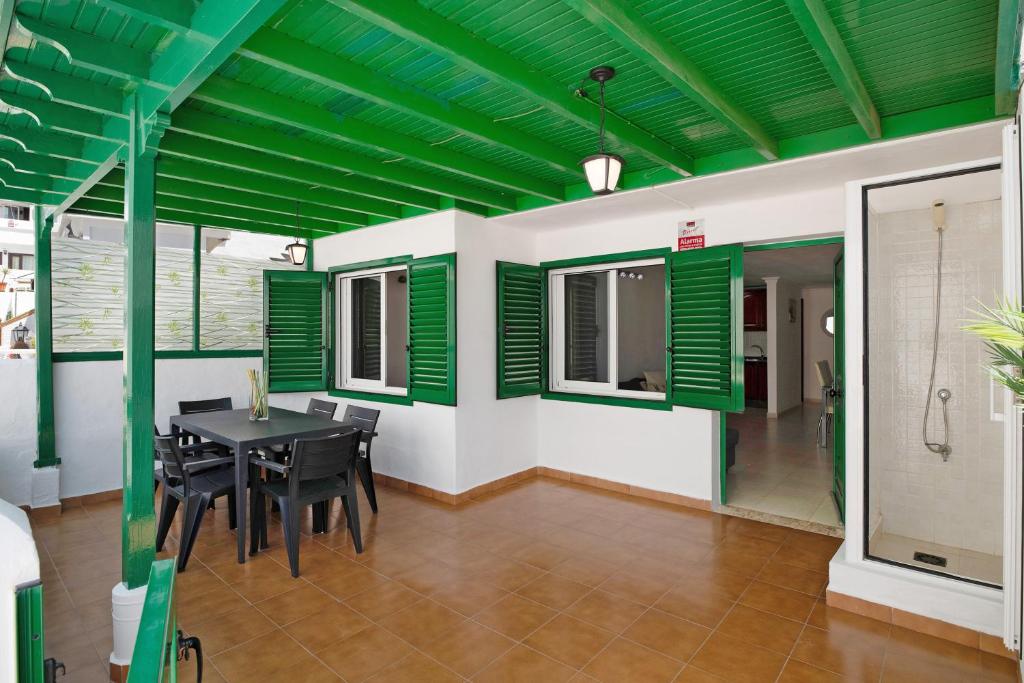 a dining room with a table and green ceilings at Casa Playa Palmeras in Puerto del Carmen
