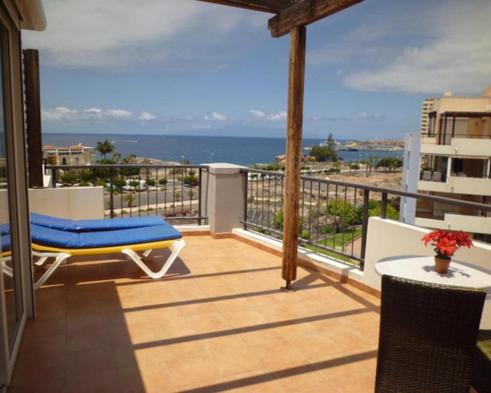 balcón con sofá azul y vistas al océano en El Rincon 4, en Los Cristianos