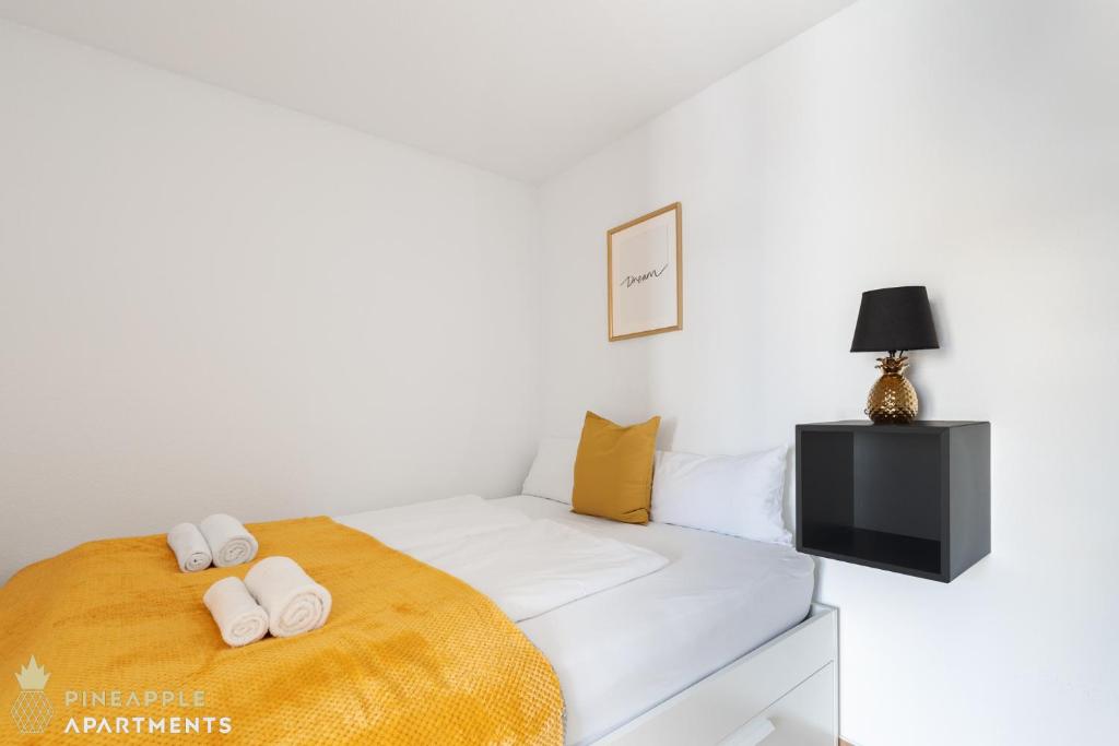 A bed or beds in a room at Pineapple Apartments Dresden Mitte II - free parking