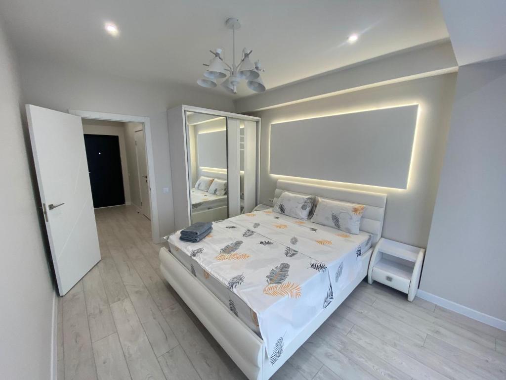 a bedroom with a large bed and a mirror at Premier Ultra Apartments Central in Chisinau in Chişinău