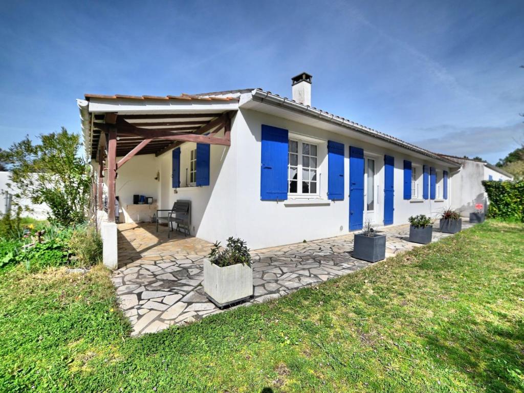 サン・ピエール・ドレロンにあるHoliday Home Mathaの青いシャッター付き小さな白い家