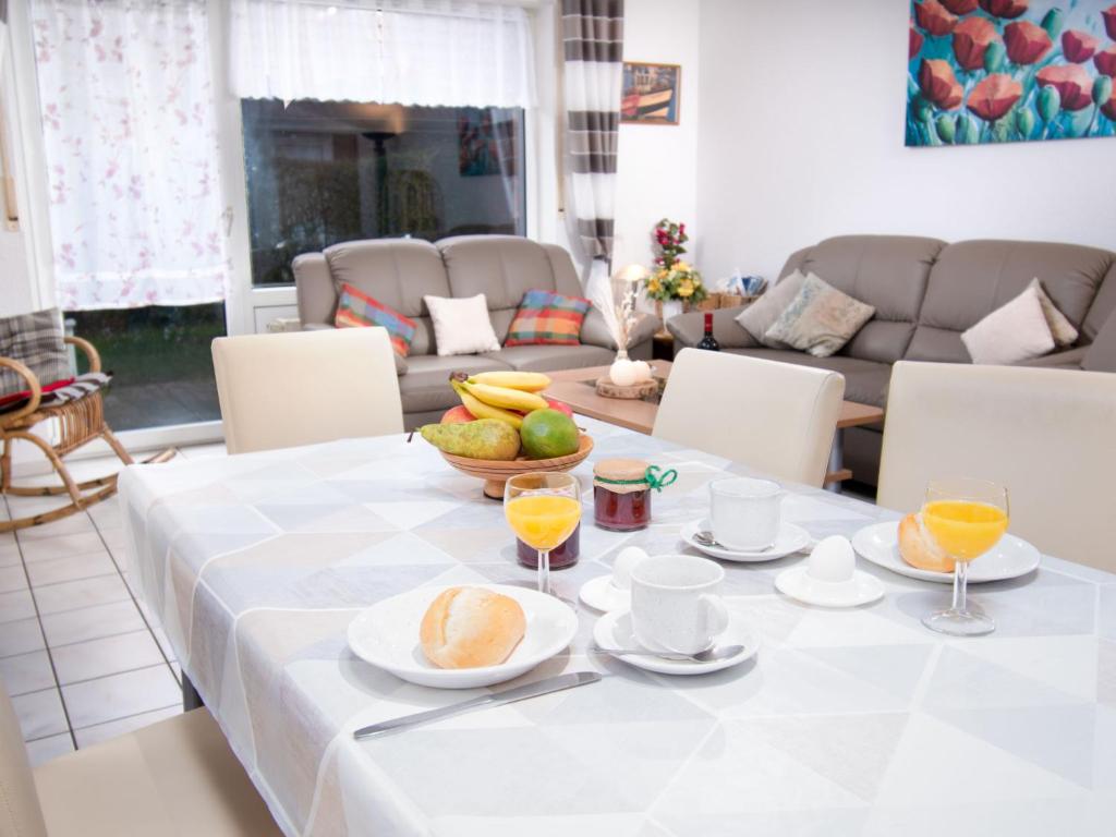 ノルトダイヒにあるHoliday Home Robbe by Interhomeの白いテーブルクロスと果物を添えたテーブル