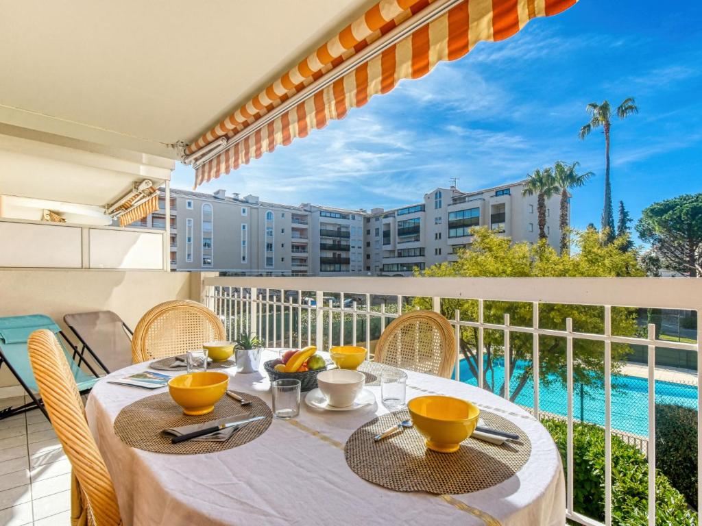 - une table sur un balcon avec vue sur la piscine dans l'établissement Apartment Résidence Les Jardins d'Eden by Interhome, à Saint-Raphaël