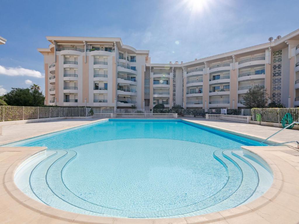 une grande piscine en face d'un grand bâtiment dans l'établissement Apartment L'Open-2 by Interhome, à Fréjus