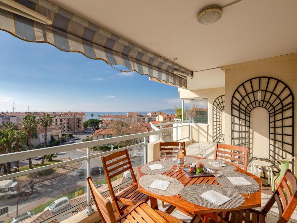 balcón con mesas y sillas y vistas a la ciudad en Apartment L'Aétius by Interhome, en Fréjus