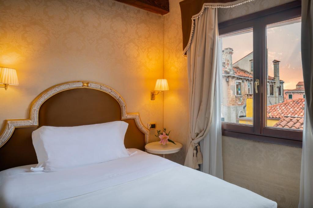 Postel nebo postele na pokoji v ubytování Maison Venezia | UNA Esperienze