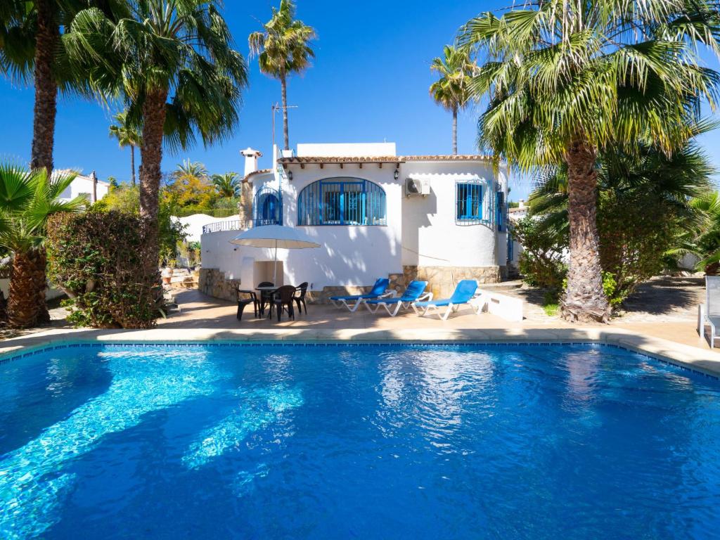 una piscina frente a una casa con palmeras en Holiday Home Carmen by Interhome en Moraira