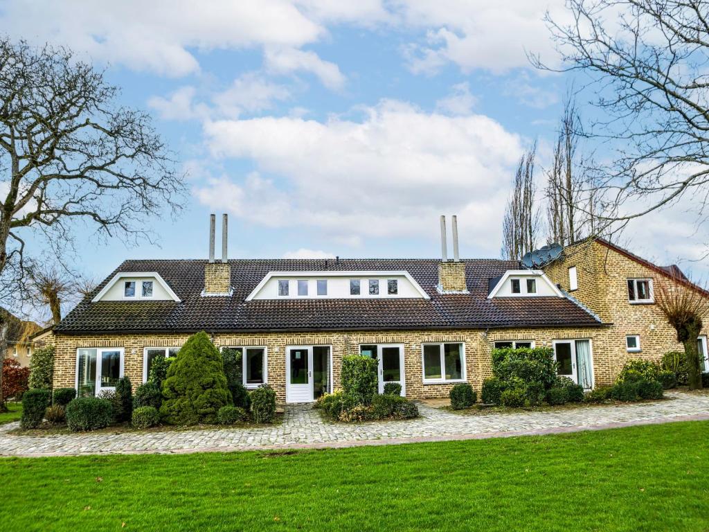 a large brick house on a green lawn at Holiday Home Bungalowpark Landsrade by Interhome in Gulpen