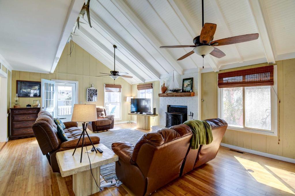 a living room with leather furniture and a ceiling fan at Ocean Isle Beach Home with Canal Views! in Ocean Isle Beach