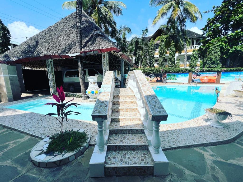 a swimming pool with a stairway leading to a resort at Lovely 5-Bed Room House With a swimming Pool in Diani Beach