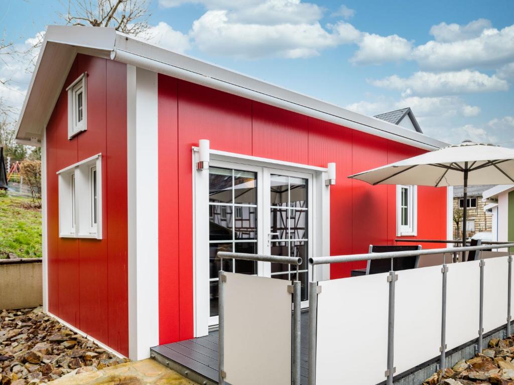 バート・マリエンベルクにあるHoliday Home Tiny Haus Westerwald 16 Red by Interhomeの傘付き赤白の建物