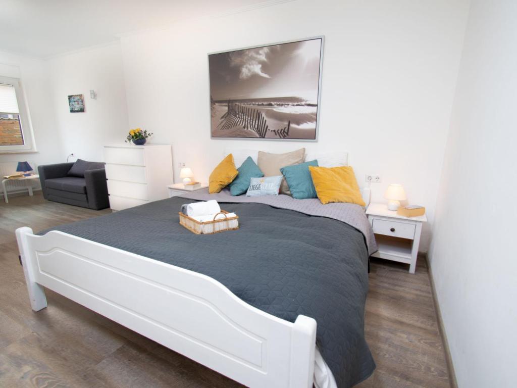 um quarto com uma grande cama branca com almofadas coloridas em Apartment Strandmuschel by Interhome em Norddeich