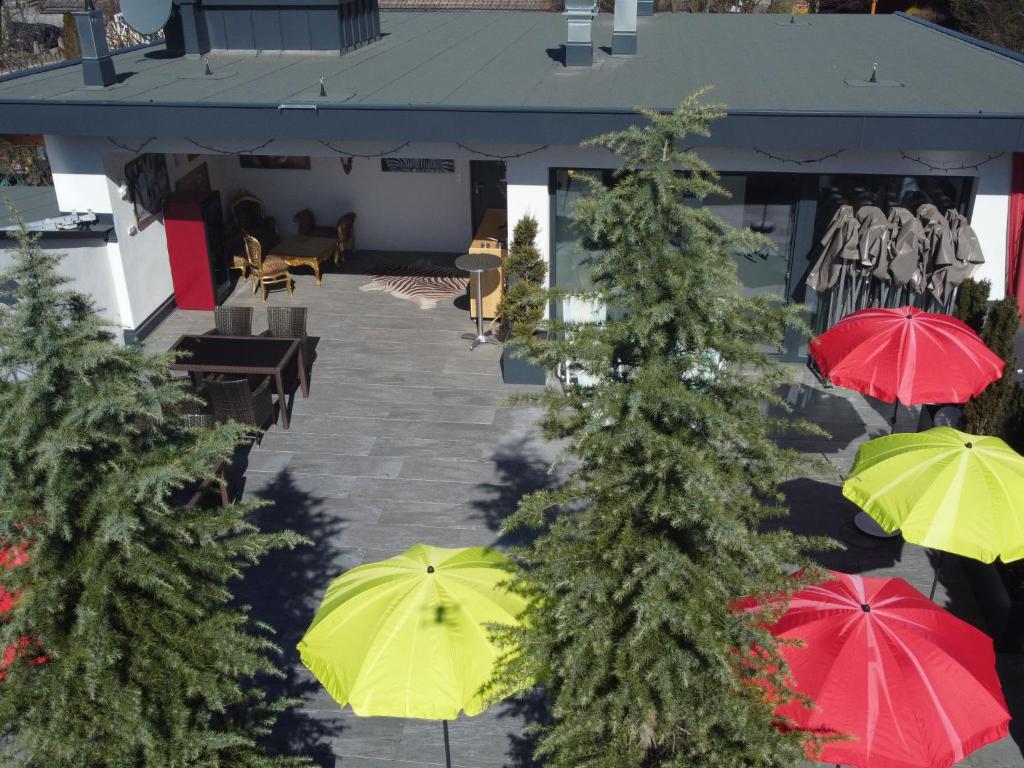 a group of green and red umbrellas in front of a building at Apartment Erzherzog's Apts-Zillertal Kaiser Lodge by Interhome in Uderns