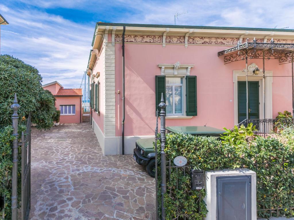 een roze huis met een auto ervoor geparkeerd bij Apartment Ponente N-2 by Interhome in San Vincenzo