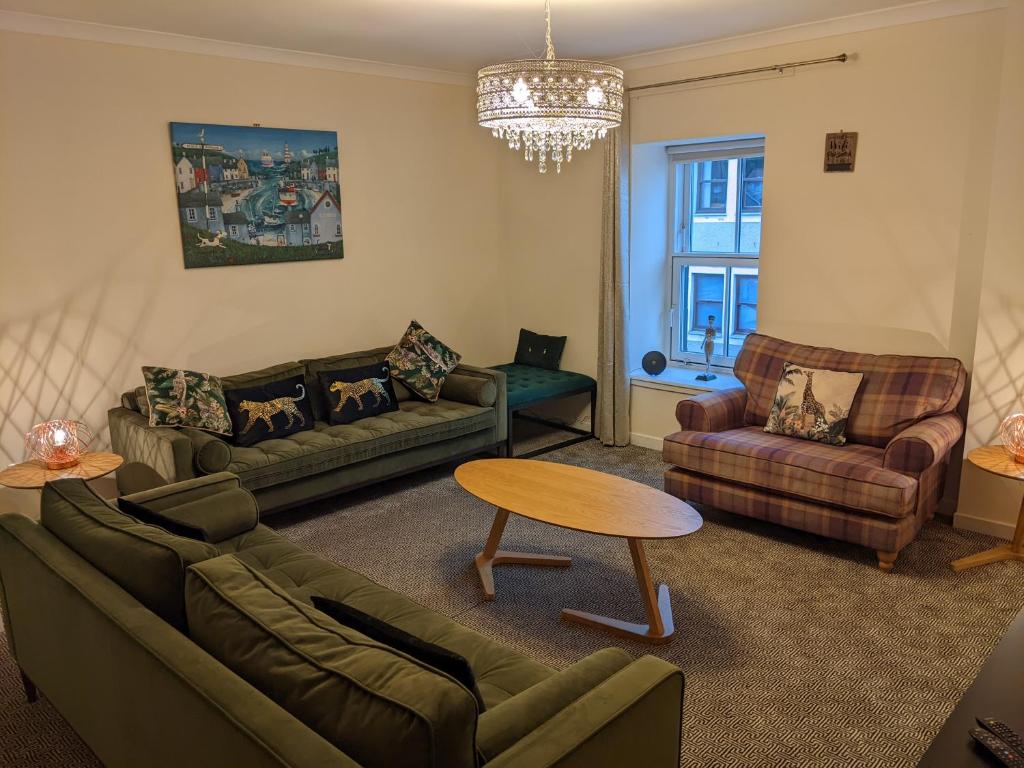 a living room with two couches and a table at sorn inn holiday apartments in Sorn