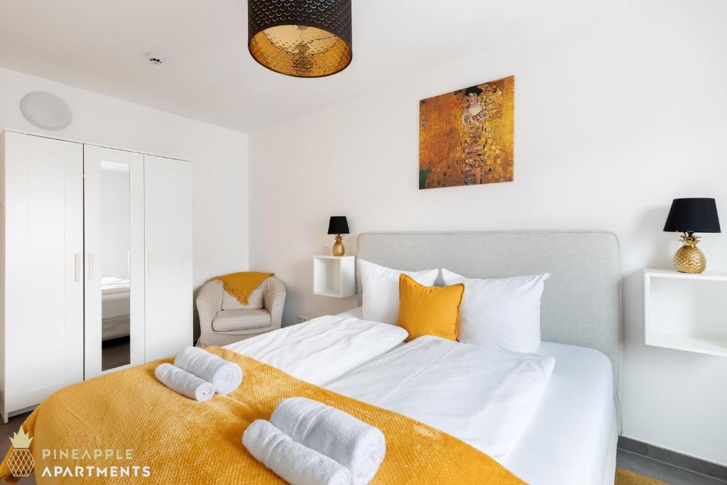 una camera da letto con un grande letto bianco con una coperta arancione di Pineapple Apartments Dresden Zwinger VI - 98 qm - 1x free parking a Dresda
