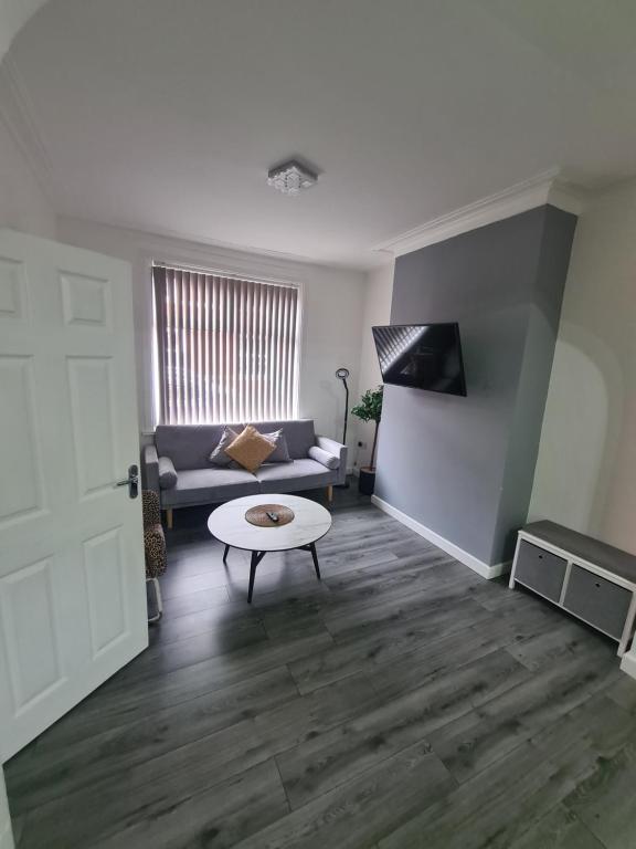 a living room with a couch and a coffee table at Lovely 2-bedroom house close to Media City. in Manchester