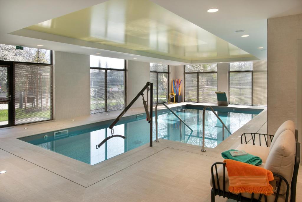 a swimming pool in a house with windows at LE JARDIN D'EDO in Mulhouse