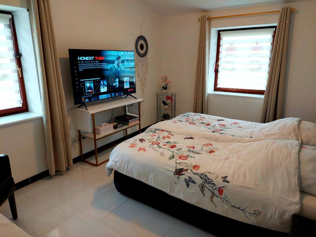 a bedroom with a bed and a flat screen tv at RYE Ferienwohnung Hamburg in Hamburg