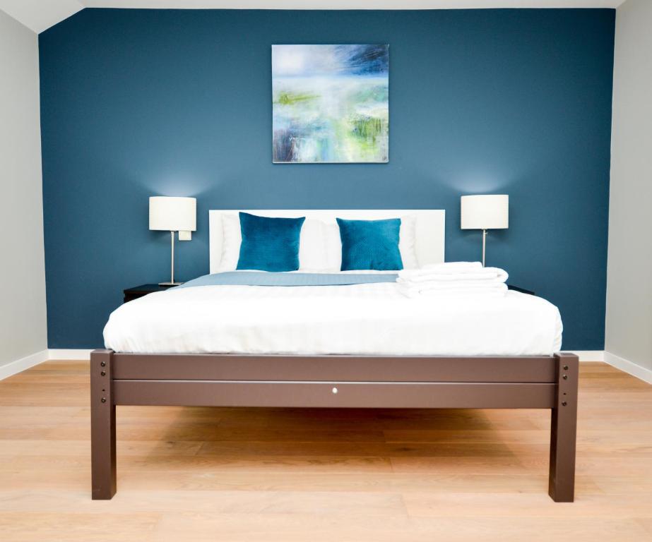 a bedroom with blue walls and a bed with blue pillows at Fitzroy Serviced Apartments by Concept Apartments in London