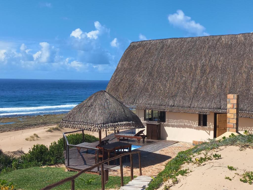 伊尼揚巴內的住宿－Khumbula iMozambique，海滩上的小屋,配有桌椅和大海