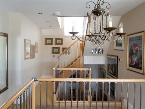 a staircase in a home with a chandelier at Birch House Bed & Breakfast in Weymouth