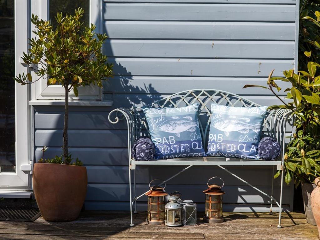 a bench sitting on a porch with pillows on it at Birch House Bed & Breakfast in Weymouth