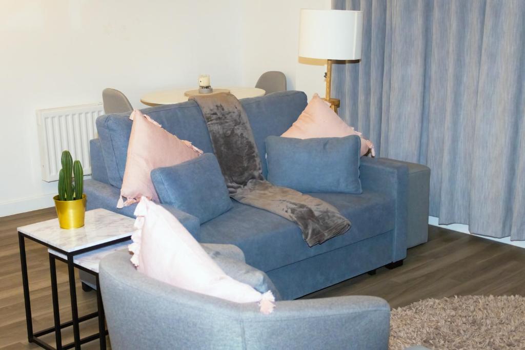 a living room with a blue couch and a table at Luxurious MK Apartment-Campbell Park in Milton Keynes