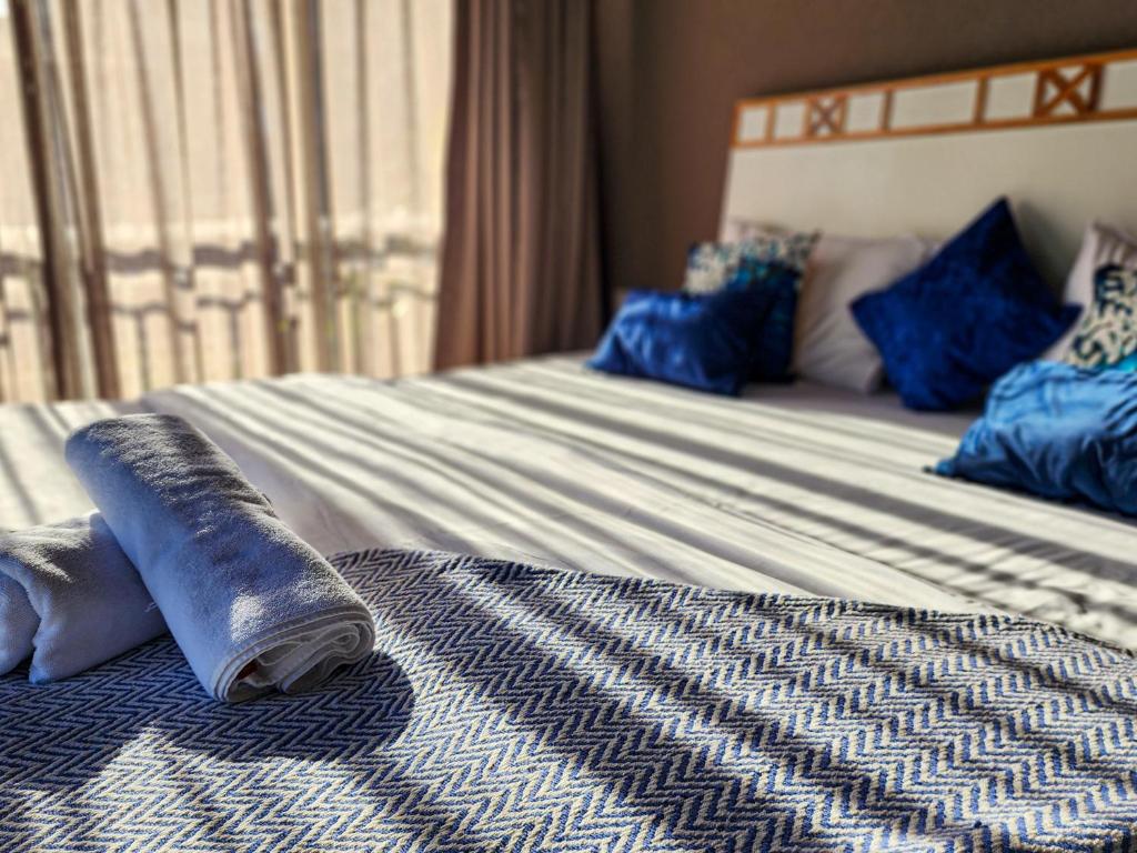 - un lit avec des draps et des oreillers bleus et blancs dans l'établissement Beach 7 mins walk Luxury villa Diva, à Calangute