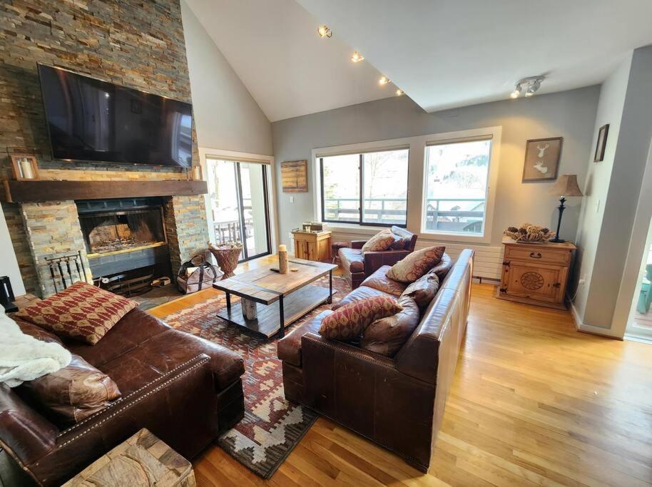 a living room with leather couches and a fireplace at White Mountain Vista! in Lincoln