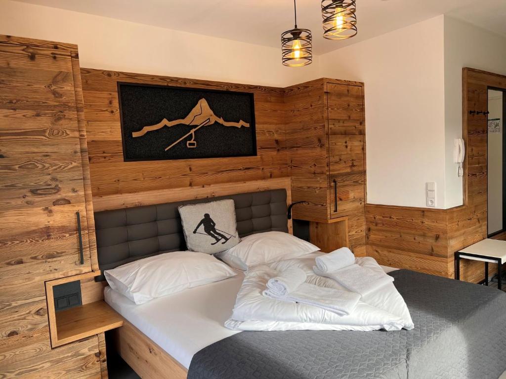 a bedroom with a bed with a wooden wall at Studio Rehkitz by Interhome in Kaprun