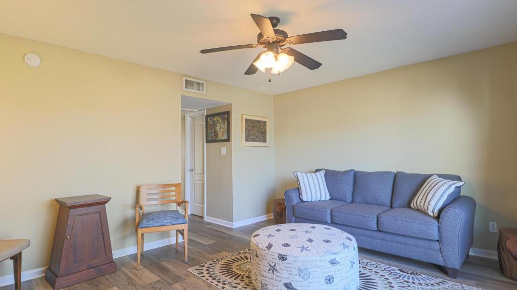 a living room with a blue couch and a ceiling fan at Oak Glen 84 in Ocean Springs