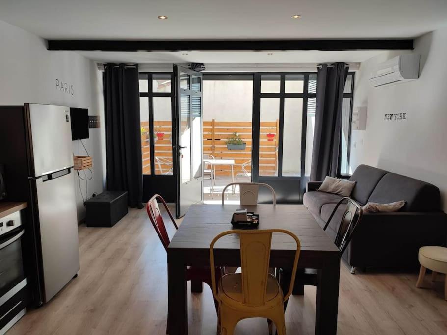 une cuisine et un salon avec une table et des chaises dans l'établissement La Bastide de Gabin / ConciergerieDameCarcas, à Carcassonne