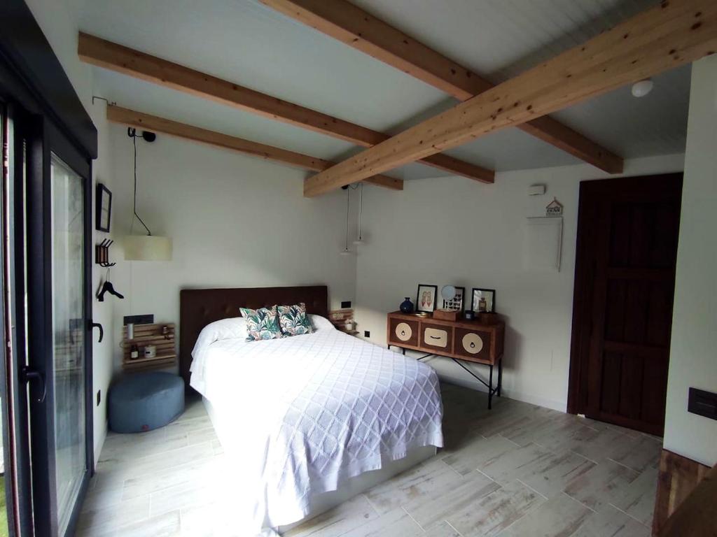 a bedroom with a white bed and wooden ceilings at Studio with furnished terrace at Riogordo in Ríogordo