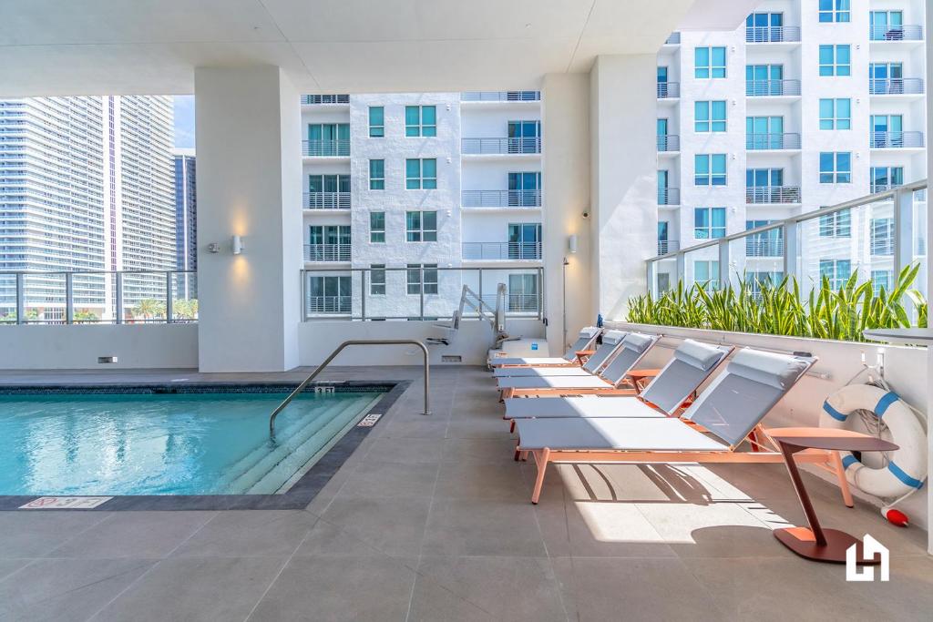 een zwembad in een gebouw met stoelen en een zwembad bij Downtown Miami Condos by Lua Host in Miami