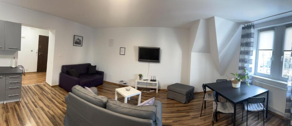 uma sala de estar com um sofá e uma mesa em Kamienica5 em Chorzów