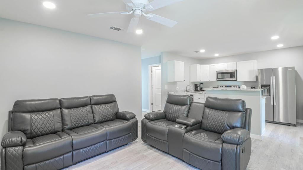 ein Wohnzimmer mit 2 Ledersofas und einer Küche in der Unterkunft Duplex On Howard - Hornsby Suite in Biloxi